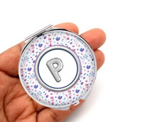 Floral Print travel purse mirror, laying on a woman's hand to show the size.