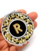 Gold Animal Print pocket mirror, laying on a woman's hand to show the size.