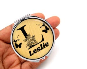 Personalized initial compact mirror custom name, laying on a woman's hand to show the size.