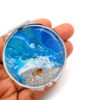 Compact mirror travel gift laying on a woman's hand to show the size. Designed by Terlis Designs.