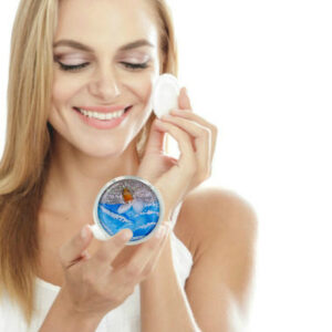 Custom cosmetic handheld mirror being used by a woman applying makeup. Created by Terlis Designs.
