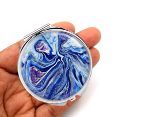 Custom double sided compact mirror laying on a woman's hand to show the size. Designed by Terlis Designs.