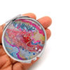 Custom double sided makeup mirror laying on a woman's hand to show the size. Designed by Terlis Designs.