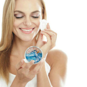 Custom silver handheld mirror being used by a woman applying makeup. Created by Terlis Designs.