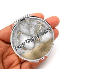 seafoam green purse compact mirror, laying on a woman's hand to show the size.