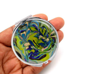 seafoam green Compact mirror laying on a woman's hand to show the size. Designed by Terlis Designs.