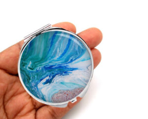 seafoam green Custom compact mirror laying on a woman's hand to show the size. Designed by Terlis Designs.