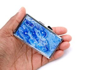 Ocean art Weekly Pill Case - PILB140, laying on a woman's hand to show the size, image by Terlis Designs.