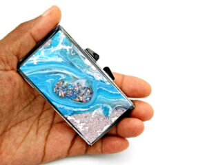 Portable Pill Case - PILB180, laying on a woman's hand to show the size, image by Terlis Designs.