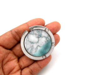 marble purse holder for bar, item sku PURH426B, laying on a woman's hand to show the size image by Terlis Designs.