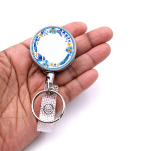 Baby Blue Floral Print badge reel - BADR458B - laying on a woman's hand to show the size. Designed By Terlis Designs.