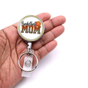 Basketball Mom retractable badge reel - BADR425 - laying on a woman's hand to show the size. Designed By Terlis Designs.