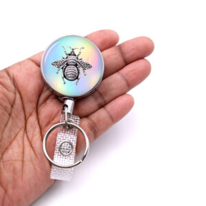 Bumble Bee retractable badge reel - BADR406 - laying on a woman's hand to show the size. Designed By Terlis Designs.