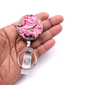 Custom name badge reel - BADR337 - laying on a woman's hand to show the size. Designed By Terlis Designs.