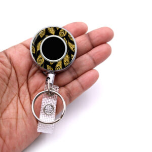 Gold Glitter doctor badge reel - BADR451B - laying on a woman's hand to show the size. Designed By Terlis Designs.