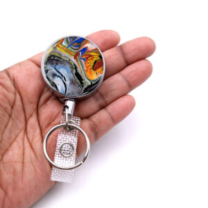 Id badge reel - BADR376 - laying on a woman's hand to show the size. Designed By Terlis Designs.