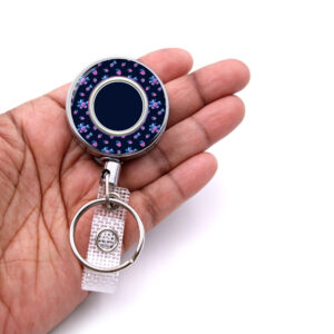 Lilac Blue Floral Print custom badge reel - BADR457B - laying on a woman's hand to show the size. Designed By Terlis Designs.