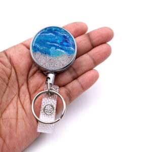 Medical badge reel - BADR444 - laying on a woman's hand to show the size. Designed By Terlis Designs.