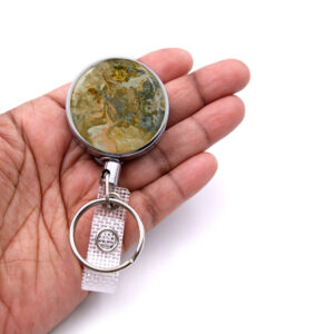 Nursing badge reel - BADR393 - laying on a woman's hand to show the size. Designed By Terlis Designs.