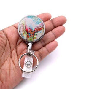 Personalized badge reel - BADR336 - laying on a woman's hand to show the size. Designed By Terlis Designs.