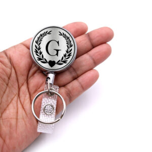 Personalized initial badge reel custom monogram - BADR417 - laying on a woman's hand to show the size. Designed By Terlis Designs.
