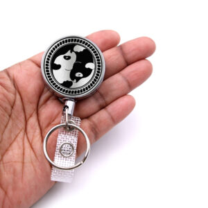 Yin Yang retractable badge reel - BADR418S1B - laying on a woman's hand to show the size. Designed By Terlis Designs.