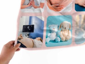 Personalized Newborn Photo Collage Blanket - BLANAN1, closeup view of the blanket held between the thumbs and fingers.